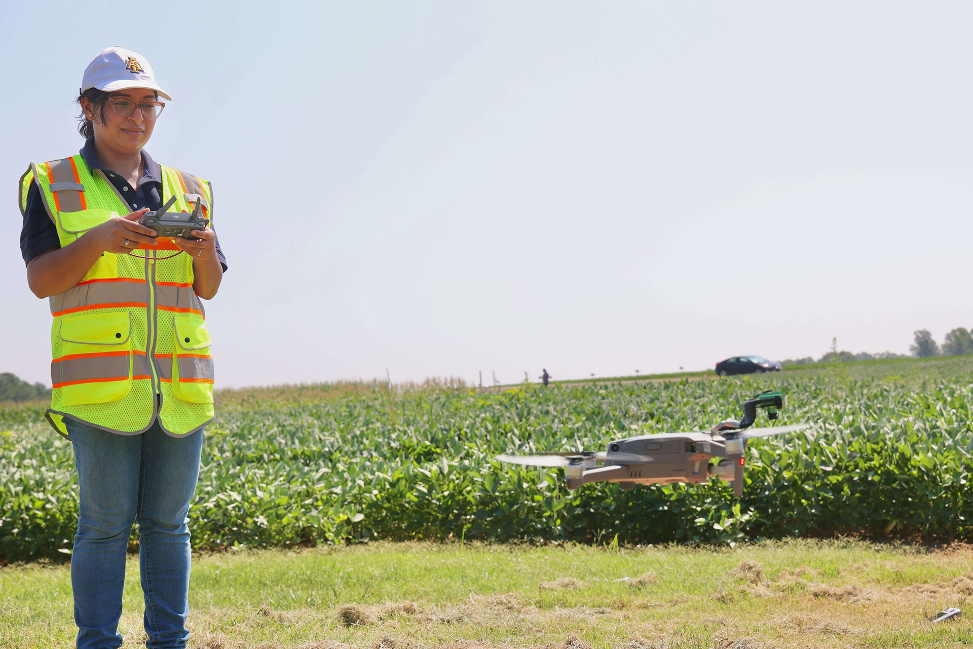 Person flying a drone near an agricultural field